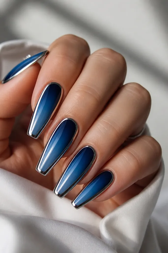 Long coffin nails with navy-to-mid-blue ombre; chrome is applied only along both sidewalls, leaving the center gradient visible.