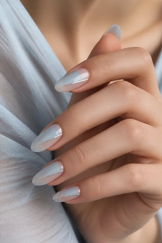 Medium almond nails with glacier blue fading to clear; a horizontal chrome line sits around the middle like a waterline.
