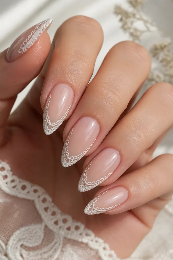 Short stiletto nails with nude glossy center; along the outer edges near the tip there is a white lace border pattern made of tiny loops; looks delicate and symmetrical.