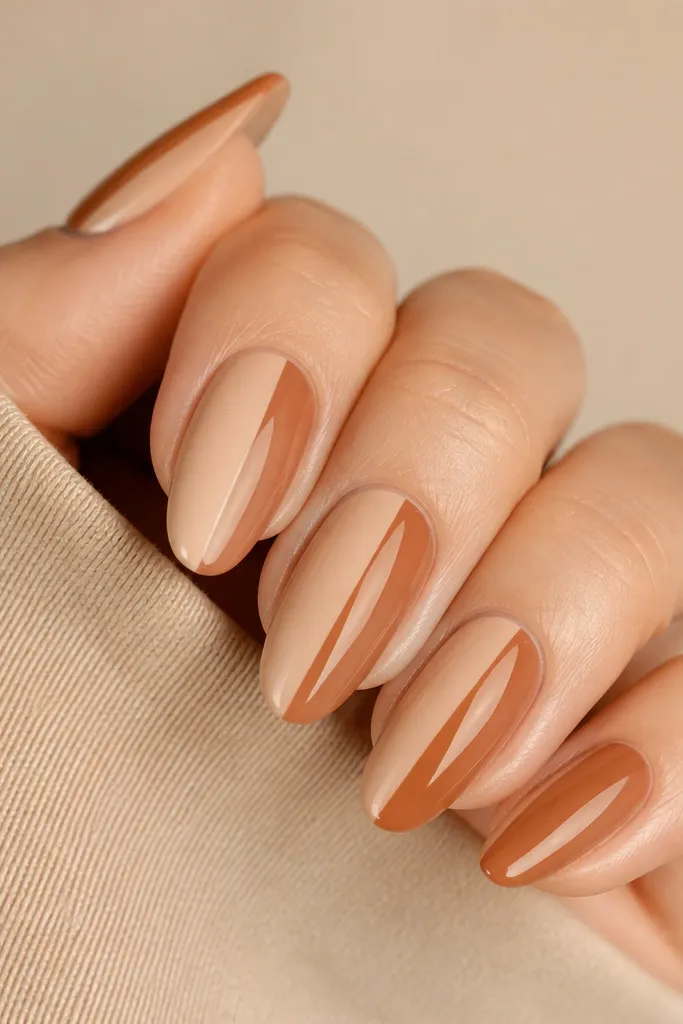 Short round nails split vertically into two colors. One side is caramel brown, the other side is a creamy off-white nude. The split line is crisp and glossy.