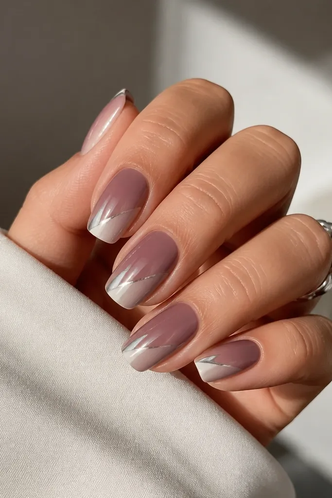 Medium squoval nails with a mauve-to-light nude ombre, with a diagonal silver chrome sweep running from side to tip.