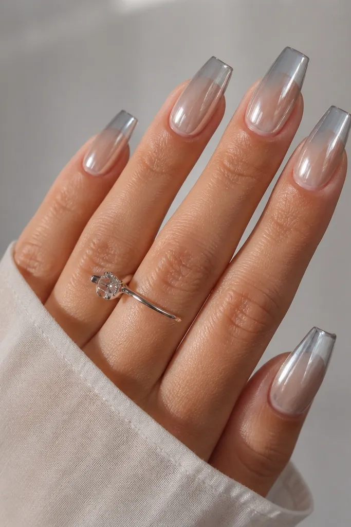 Medium coffin nails with a clear jelly base that fades from translucent near the cuticle into a soft gray at the tip; silver chrome is applied over the entire nail with a glassy, see-through look.