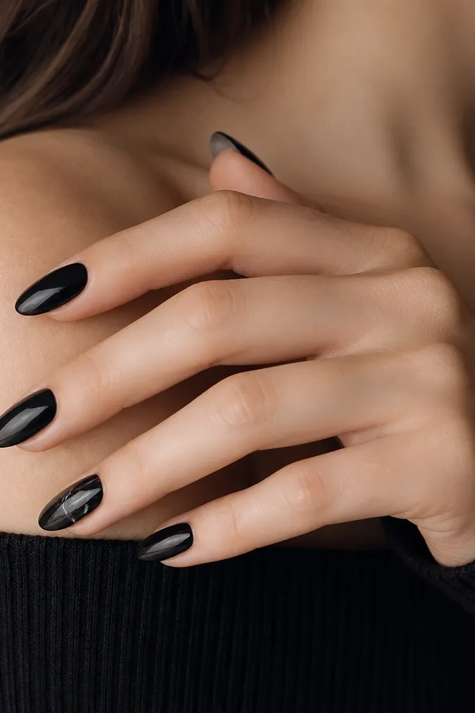 Most nails are solid black; one or two nails have thin white-gray marble veins branching through the black, with a glossy finish.