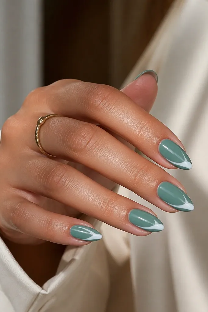Short stiletto nails in glossy sea glass teal. Each nail has a white swoosh near the tip, curving along one side and ending at the point.
