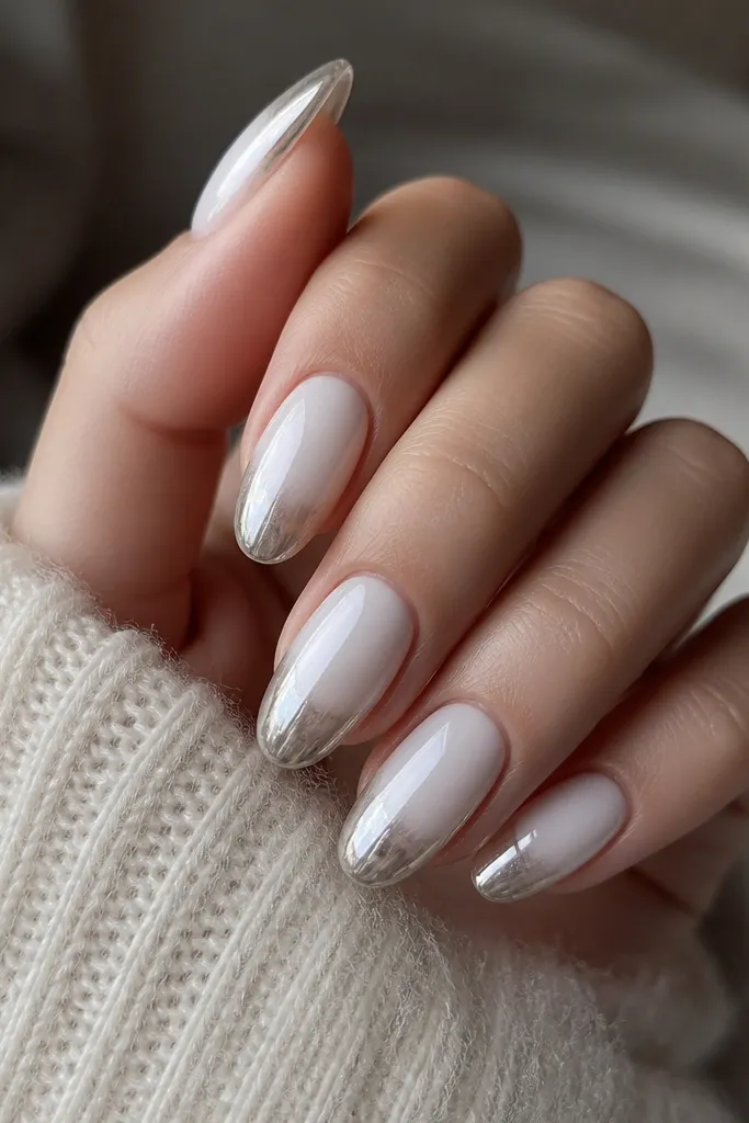 Medium nails with a white ombre base fading to a jelly-like translucent white near the tips. The tips have a silver chrome jelly layer that looks glossy and slightly see-through, not opaque. Smooth gradient blend into chrome.