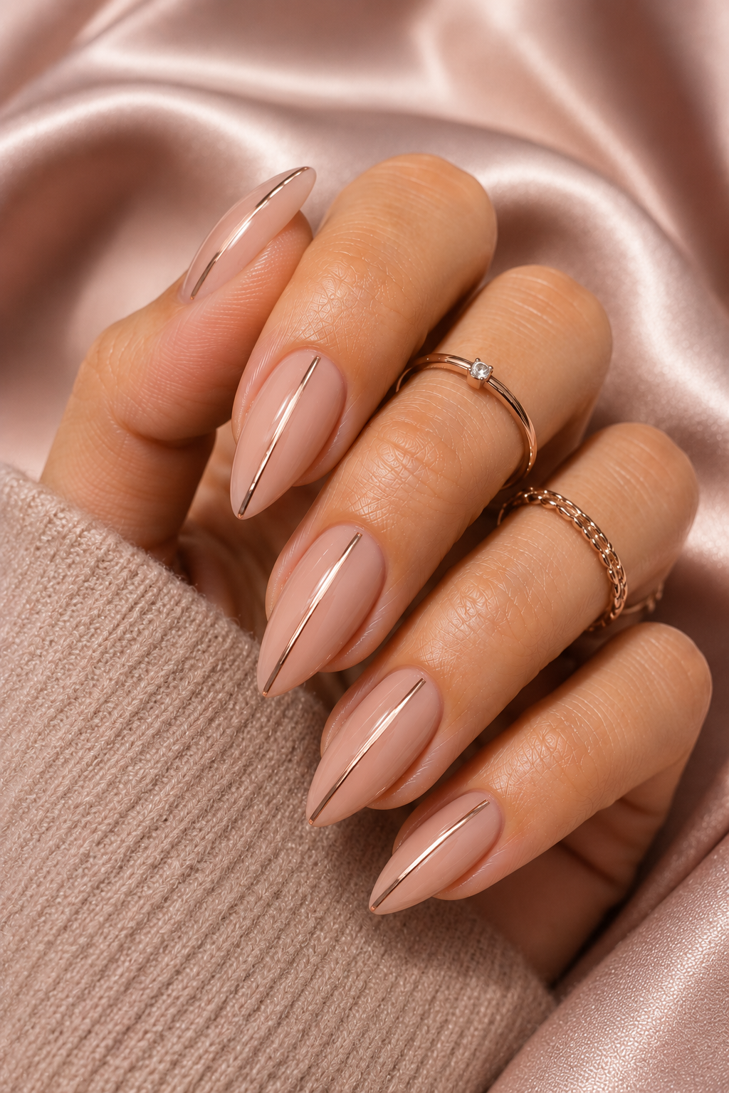Short stiletto nails with a pale pink base. A single vertical stripe runs down the center in rose chrome, ending 1 mm above the tip. The stripe is mirror-like and perfectly straight.