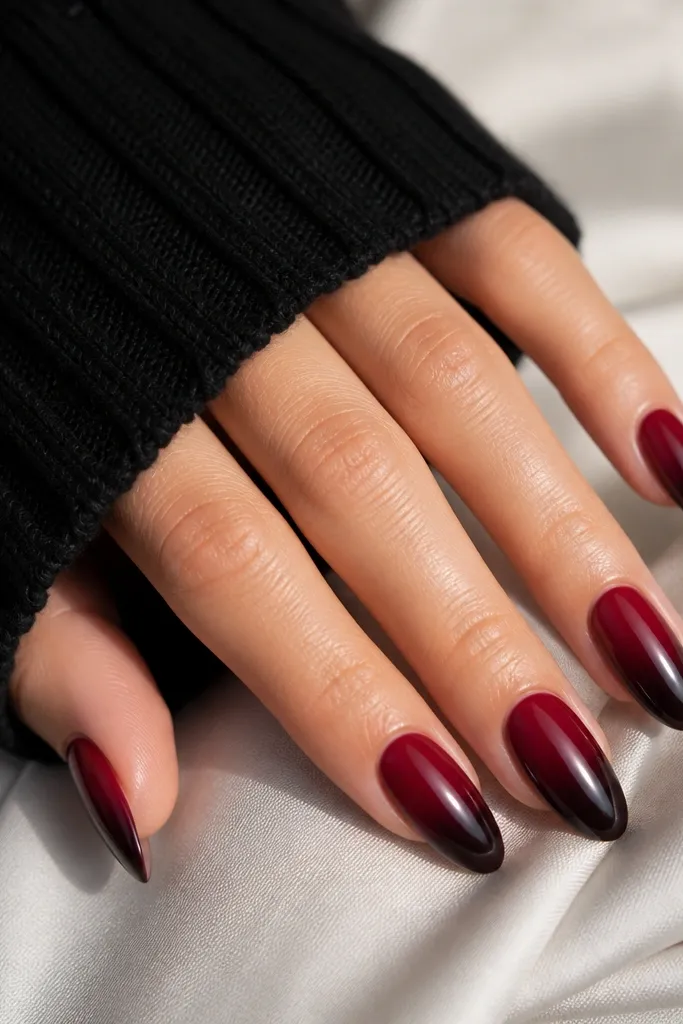 Almond nails with deep red starting at the cuticle and fading into near-black at the very tips. The transition is smooth and glossy.