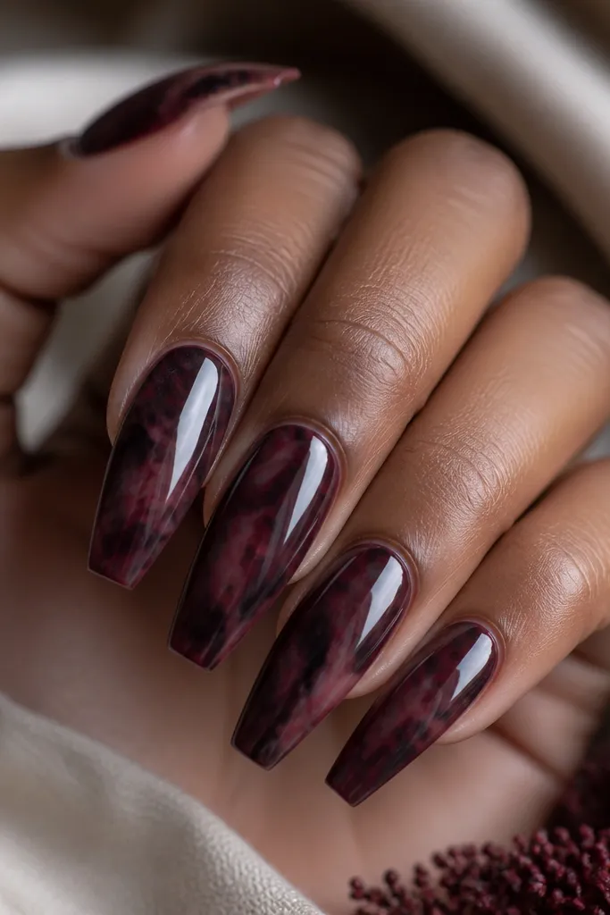 Medium coffin nails. The base is deep burgundy. Marble swirls in smoky black and muted wine create a cloudy, feathered pattern with no bright white streaks.