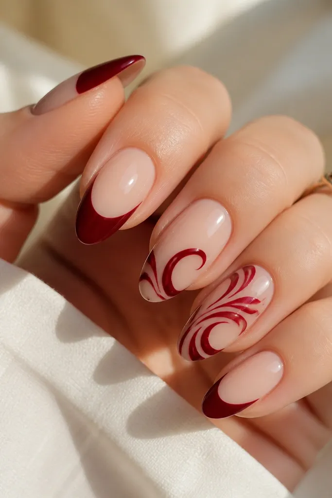 All nails are deep red glossy. The ring fingers and thumbs have thin white swirls like ornament hooks, plus tiny gold dots at the ends. The swirls are fine-lined and spaced out.