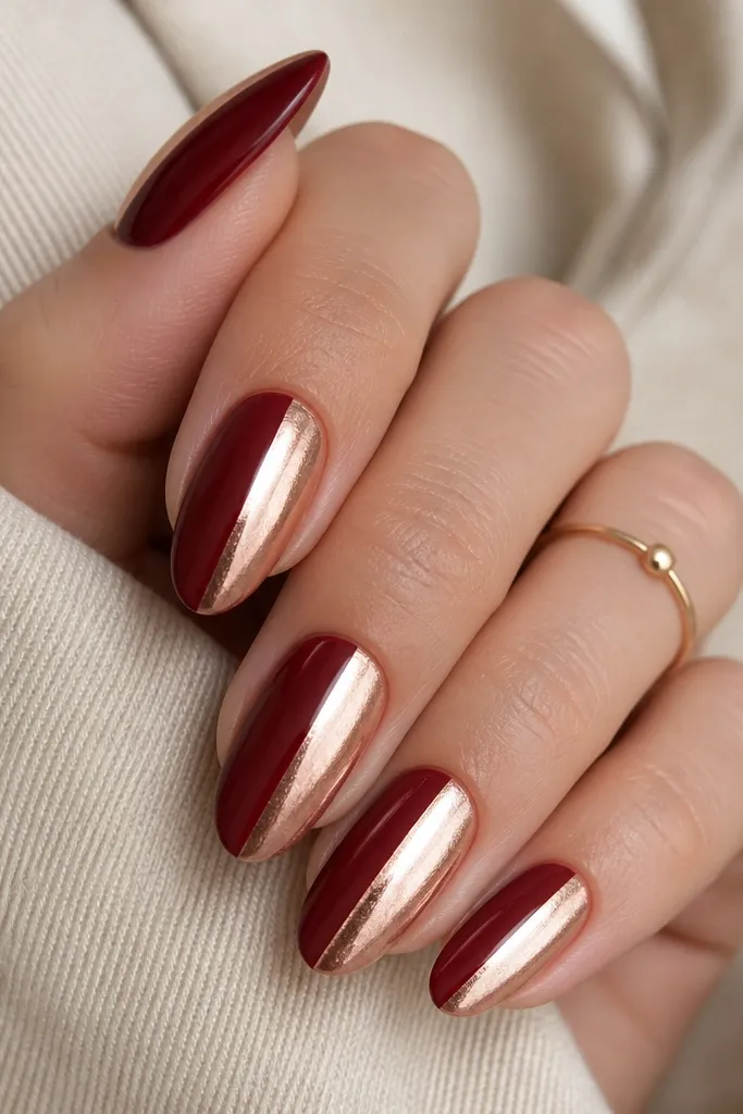 Each nail is split vertically: one side is deep oxblood glossy, the other side is rose gold metallic foil. The split line is straight and centered.