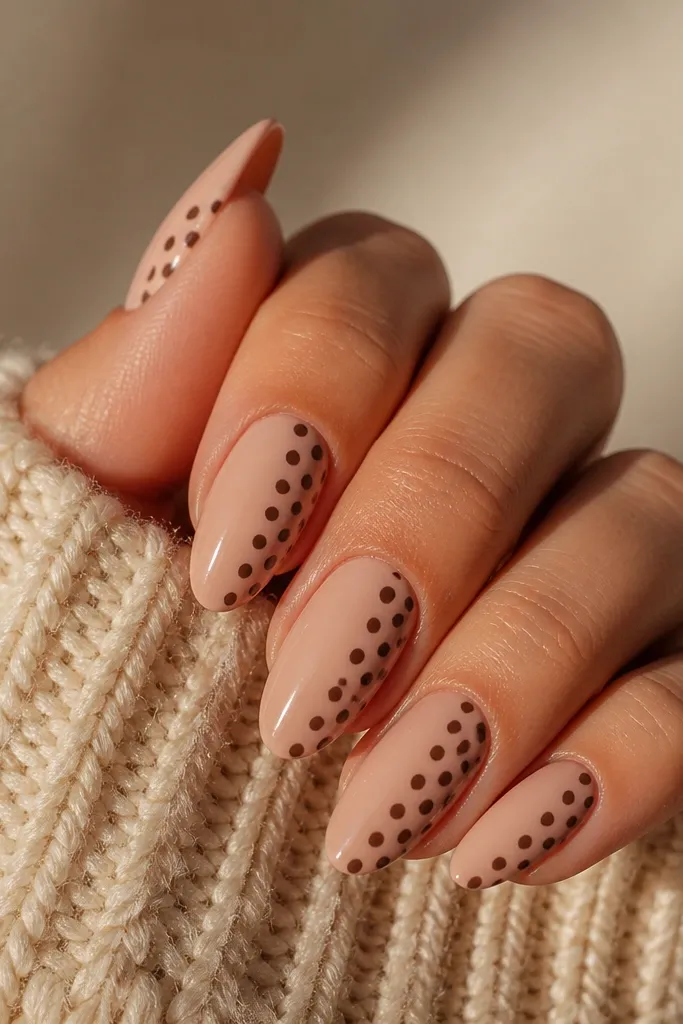 Nude nails with brown dots only on the left half of each nail. The right half is clean nude with a smooth glossy finish.