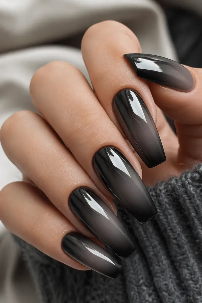Medium coffin nails with charcoal ombre fading into near-black tips; black mirror chrome is concentrated on the top 1/3 of the nail.