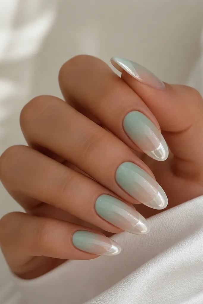 Long almond nails with seafoam green ombre fading into sheer; white chrome is applied in a rounded bubble shape at the tip.