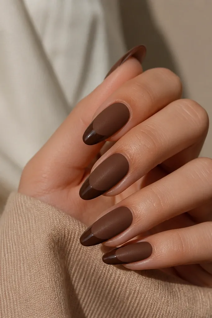 Short nails painted in matte cocoa brown. The very top half of each nail has a glossy sheen, creating a clear split line between matte bottom and glossy top.
