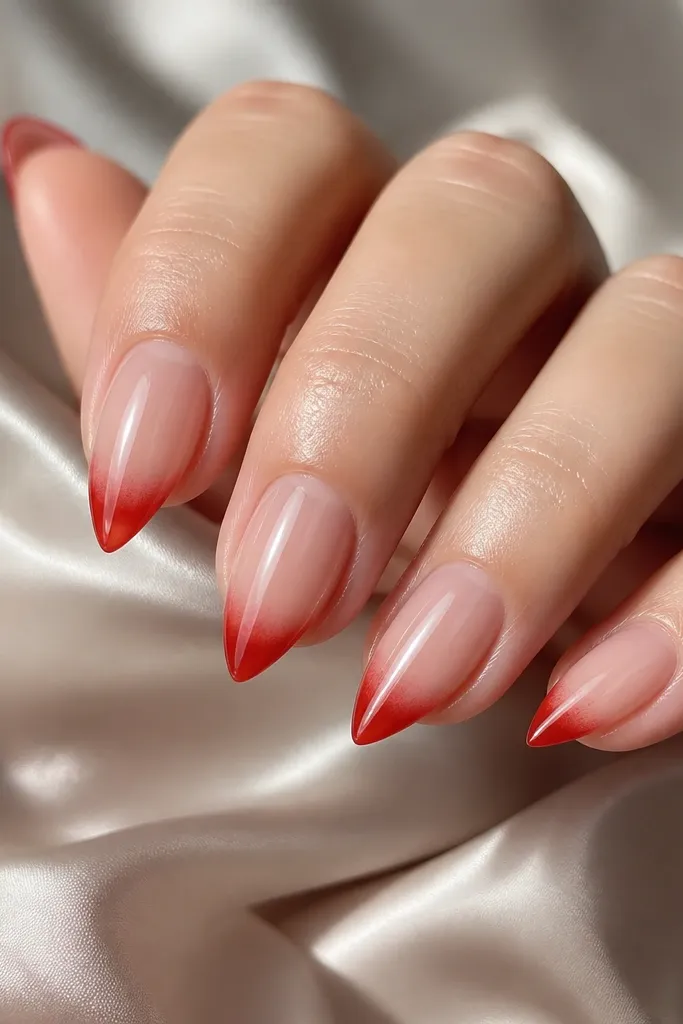 Short stiletto nails with a clear jelly base. The free edge has a strawberry red jelly tip that looks see-through, with a soft gradient into the clear. Glossy.