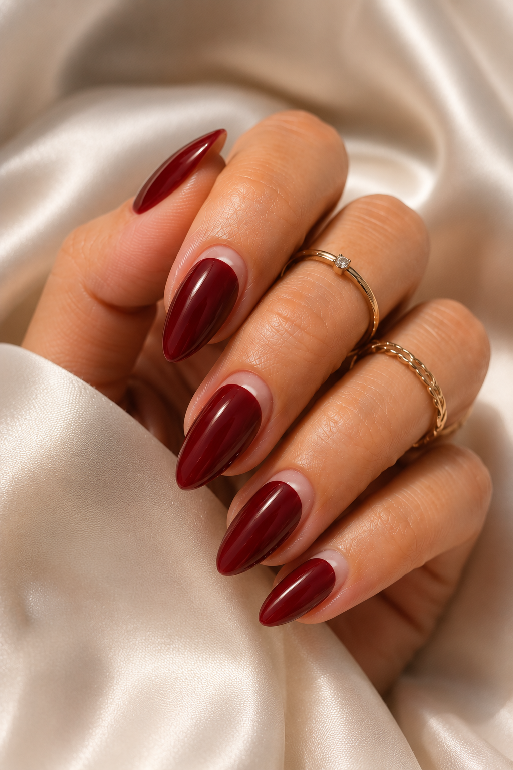 Short stiletto nails in deep red glossy. On each nail there's a thin clear stripe running vertically from just below the cuticle toward the center, leaving bare nail visible. The stripe is straight and narrow.