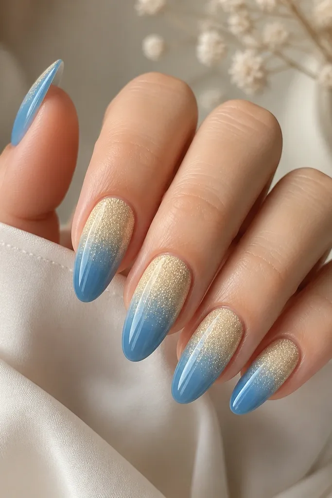 Almond nails with a pale yellow glitter fade from cuticle down. The bottom third turns into glossy blue, with a smooth blend between glitter and blue. Glossy finish.