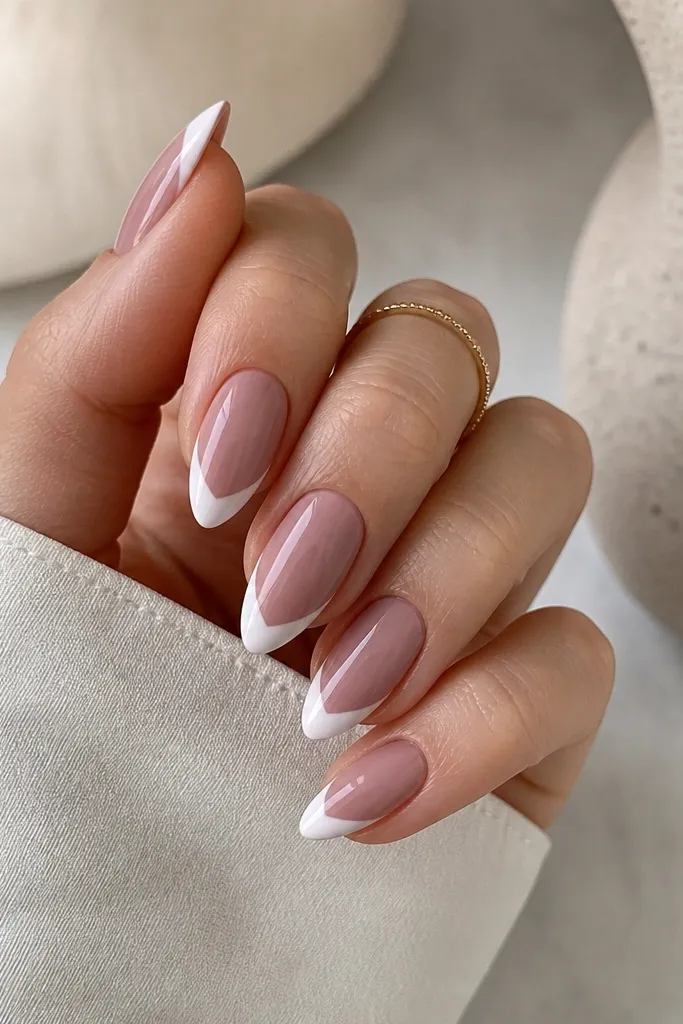 Short stiletto nails with a cool mauve sheer base and a diagonal French line in white across the tip, glossy finish.
