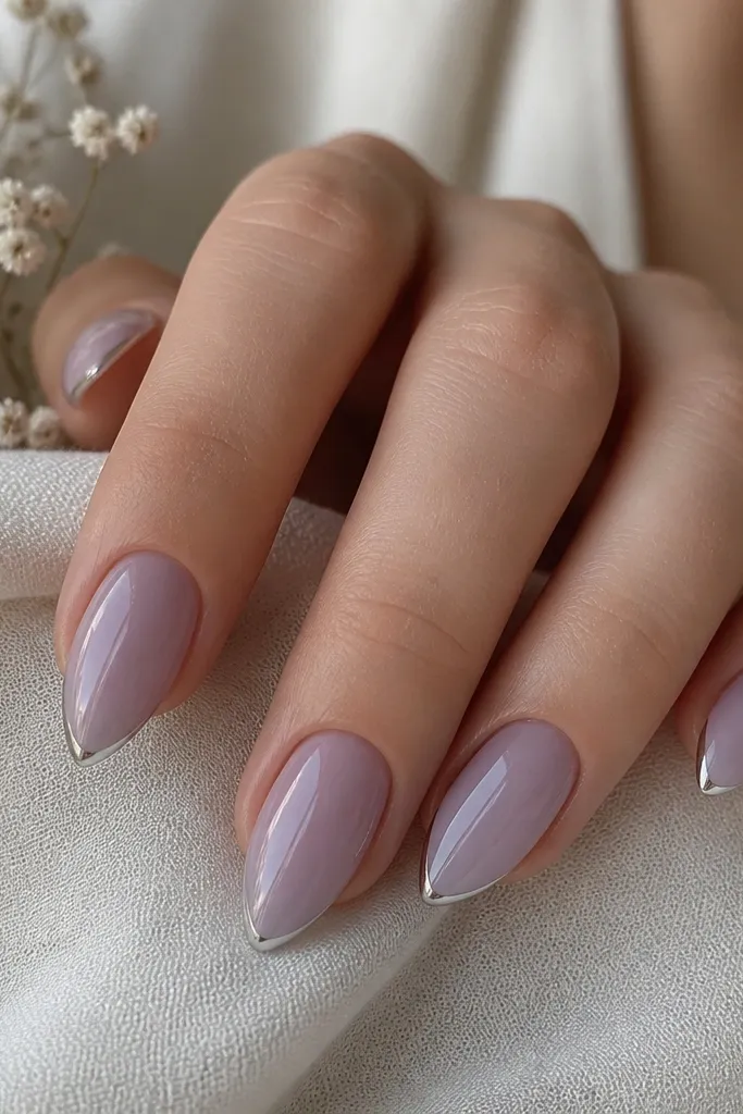 Short stiletto nails in lavender sheer; a thin silver line forms a halo around the tip edge, glossy finish.
