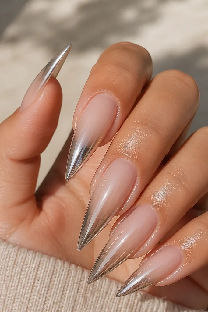 A nude ombre fades from skin-toned at cuticle to pale nude at tip, with a sharp mirror chrome triangle concentrated at the very tip.