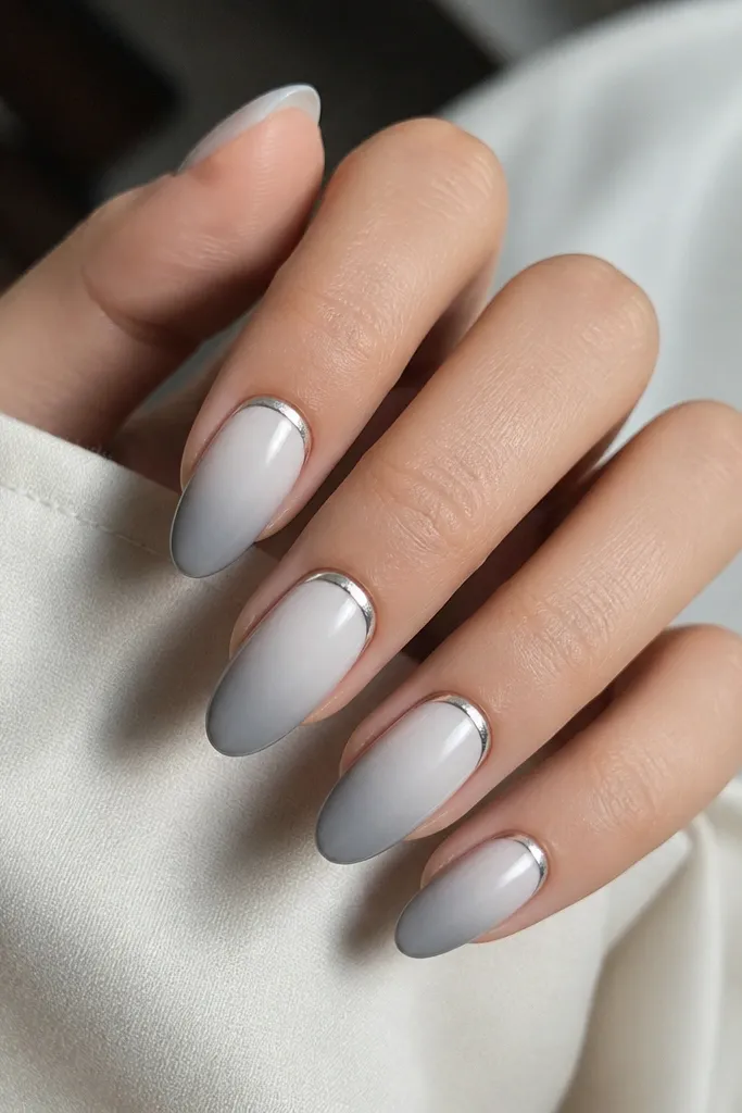 Nails fade from white at the cuticle to cool gray at the tips, with a thin silver chrome halo ring around the cuticle area.