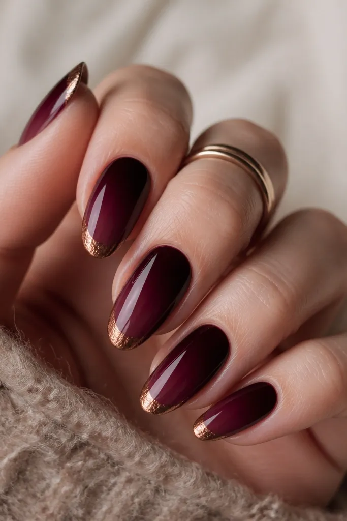 Burgundy-to-wine ombre fades from deep burgundy at the cuticle to wine at the tips, with a copper foil chrome edge that looks slightly textured and metallic.