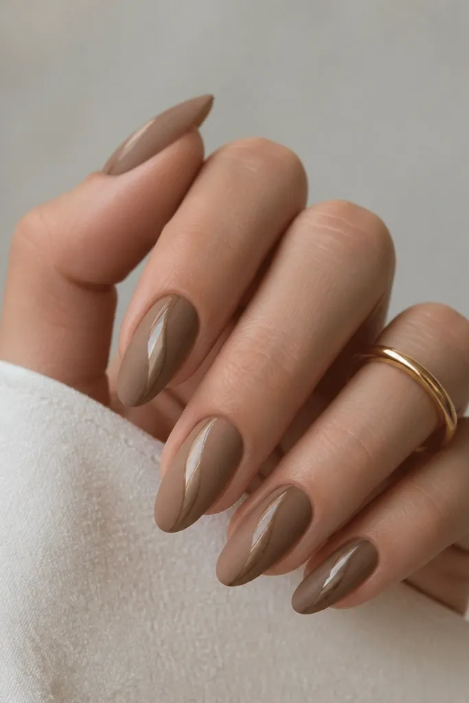 Nails have a matte light brown background. Only the cat-eye stripe area looks glossy and reflective, creating a stripe-in-glass effect.