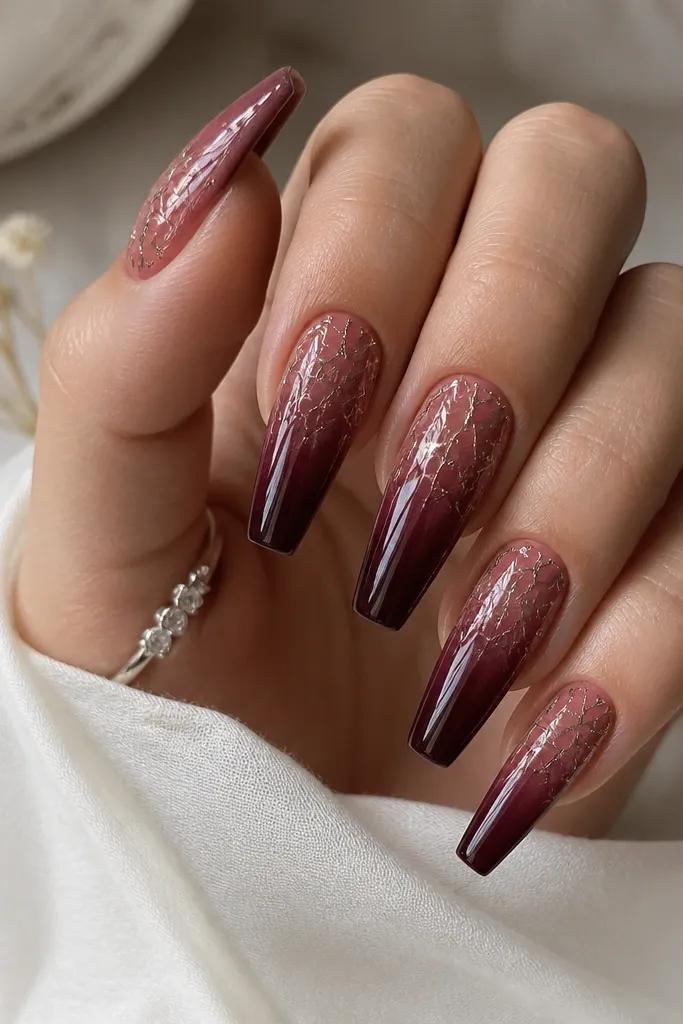 Coffin nails with a burgundy ombre fading from sheer berry at cuticle to deep wine at tips. Chrome foil crackle lines run through the top half, with a mirror shine.