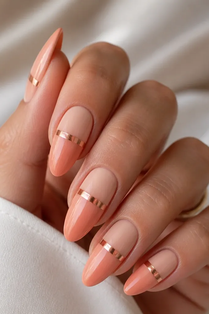 Almond nails with a peach ombre fading from light peach at cuticle to soft coral at tips. Rose gold chrome forms a halo band around the mid-nail, fading at both edges.