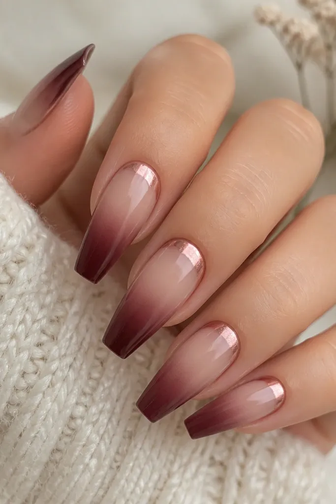 Coffin nails with a soft ombre from beige at the cuticle to burgundy at the tips. Rose chrome is applied as a 'crown' band across the top third, with a smooth fade down each side.