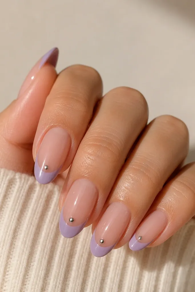 Coffin nails with sheer nude base; lavender French tips with a glossy finish; a single chrome dot accent at the center of each tip; glossy top coat.