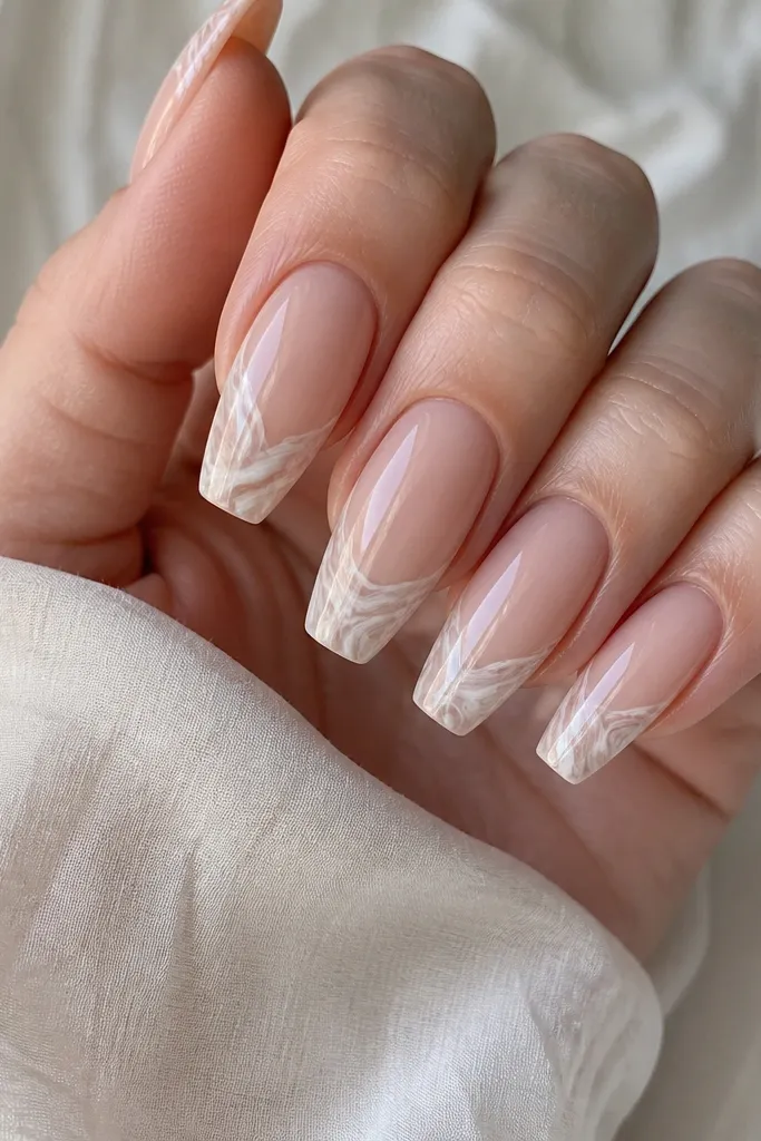 Coffin nails with nude base and milky white marble swirling only on the tips. The swirls are thin gray-beige lines, glossy overall.