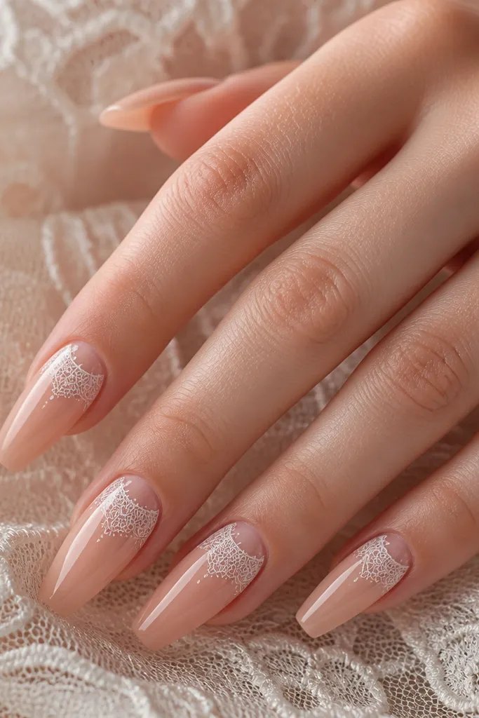 Nude coffin nails with thin white lace-like linework near the center and cuticle area. Glossy finish with clean, delicate lines.