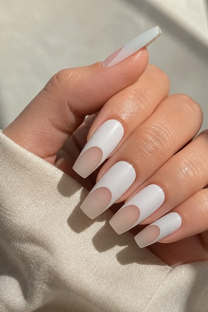 Coffin nails with sheer nude center and chalky matte white on the top half. The matte looks velvety, edges are crisp.
