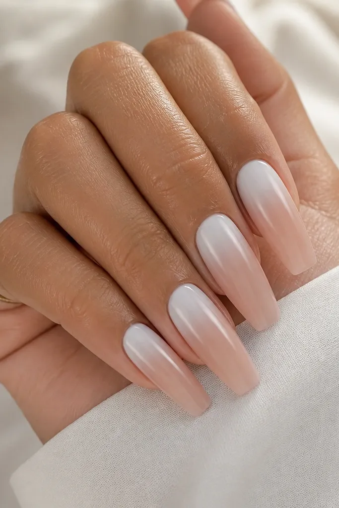 Coffin nails with a nude base. White fades out from the cuticle area into nude, creating a soft halo effect. Glossy finish.