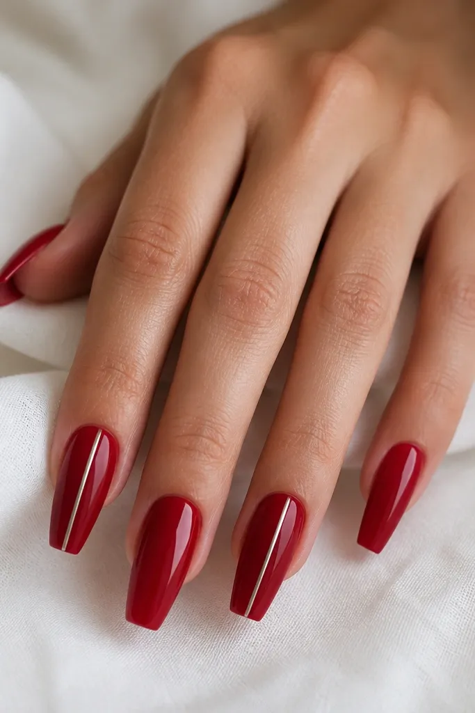 Red coffin nails, glossy, with one thin silver chrome line running vertically down the middle of each nail or every other nail.