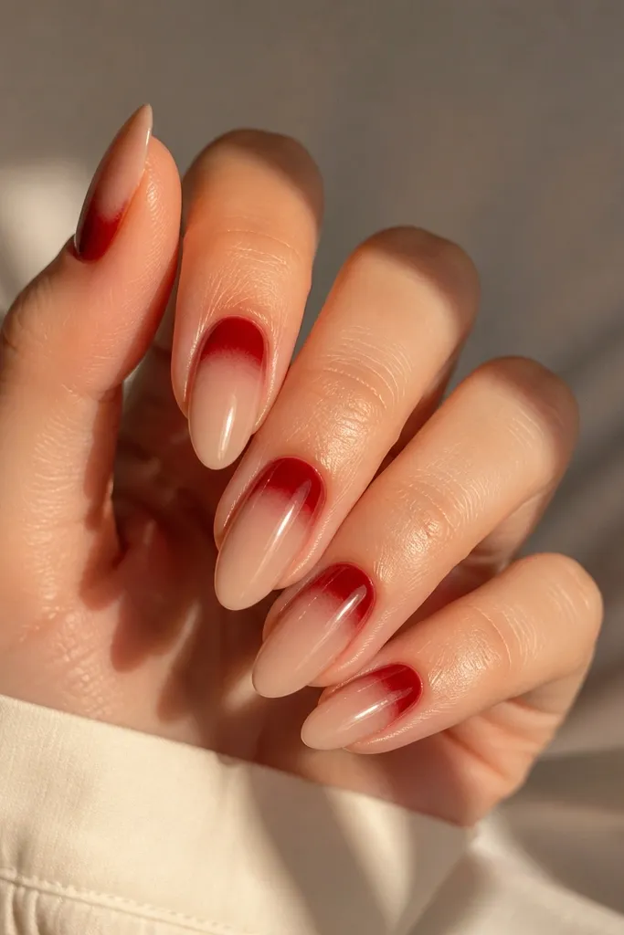 Coffin nails with a clear or nude cuticle that fades into full red toward the tip; glossy finish.