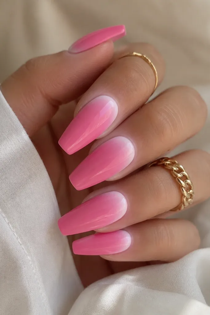 Coffin nails in bright bubblegum pink. Around each cuticle there's a soft frosted white ring, fading outward like a halo.