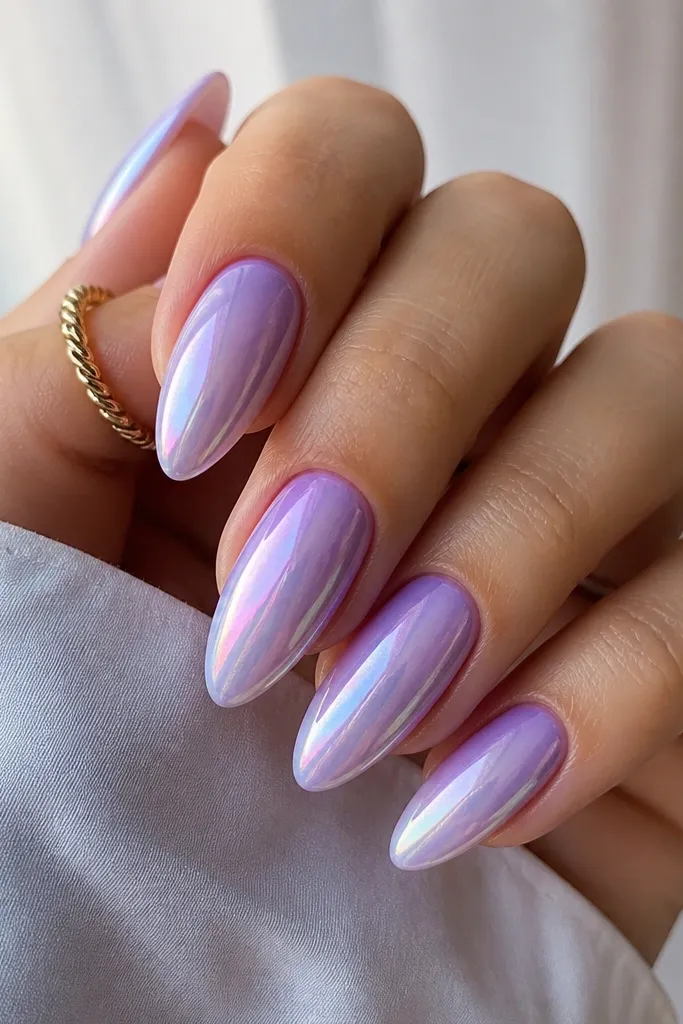 Almond nails with a lilac ombre that fades from soft lavender at the cuticle to pale violet near the tips. The chrome shifts color - you see hints of teal and pink in the reflections, with a glossy topcoat.