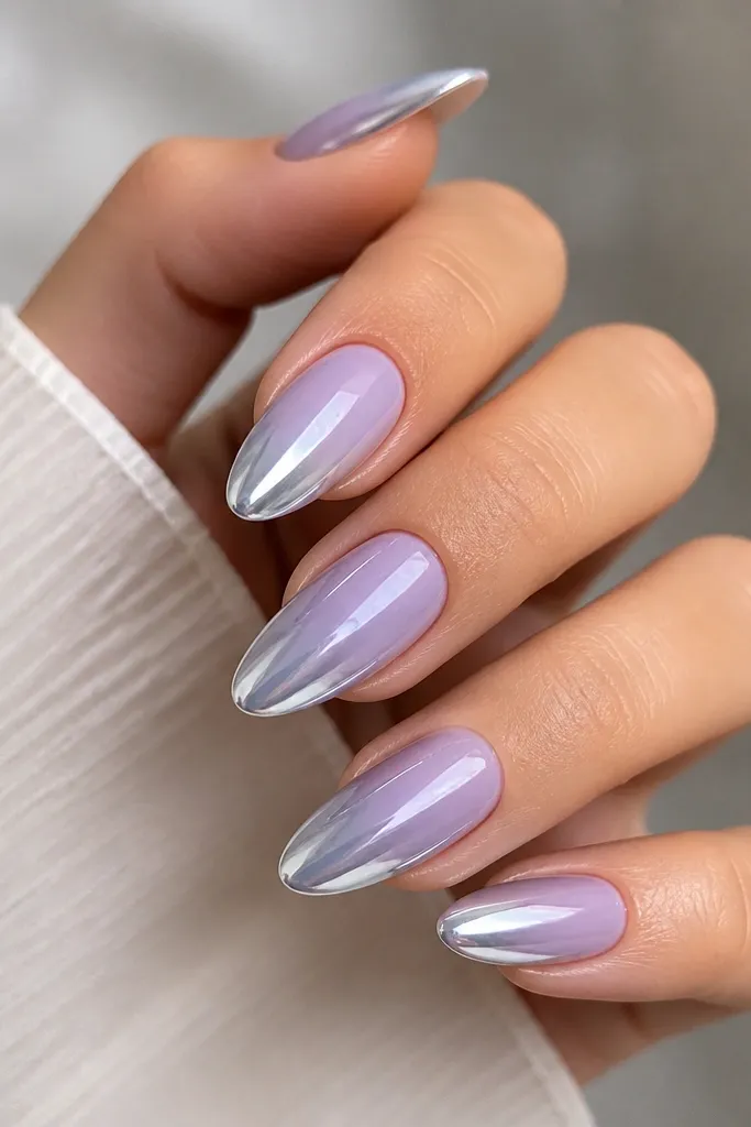 Almond nails with a soft lavender ombre that turns into cool platinum chrome at the tips. The lavender looks like a misty haze, and the chrome is bright and reflective with sharp mirror highlights.