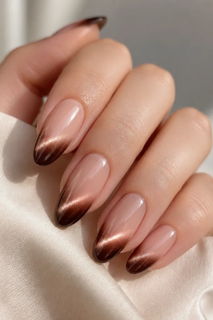 Nails with a sheer nude base that fades into a carob-brown ombré French tip. The cat-eye beam is strongest near the tip and fades slightly toward the cuticle. Glossy and smooth gradient.
