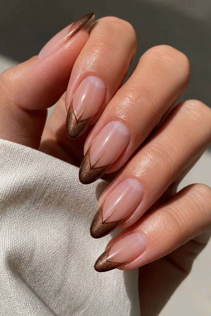 Glossy sheer nude nails with a brown cat eye French tip. The cuticle area has a V-shaped negative space in the center, showing your natural nail. The cat-eye beam runs from the V down the center.