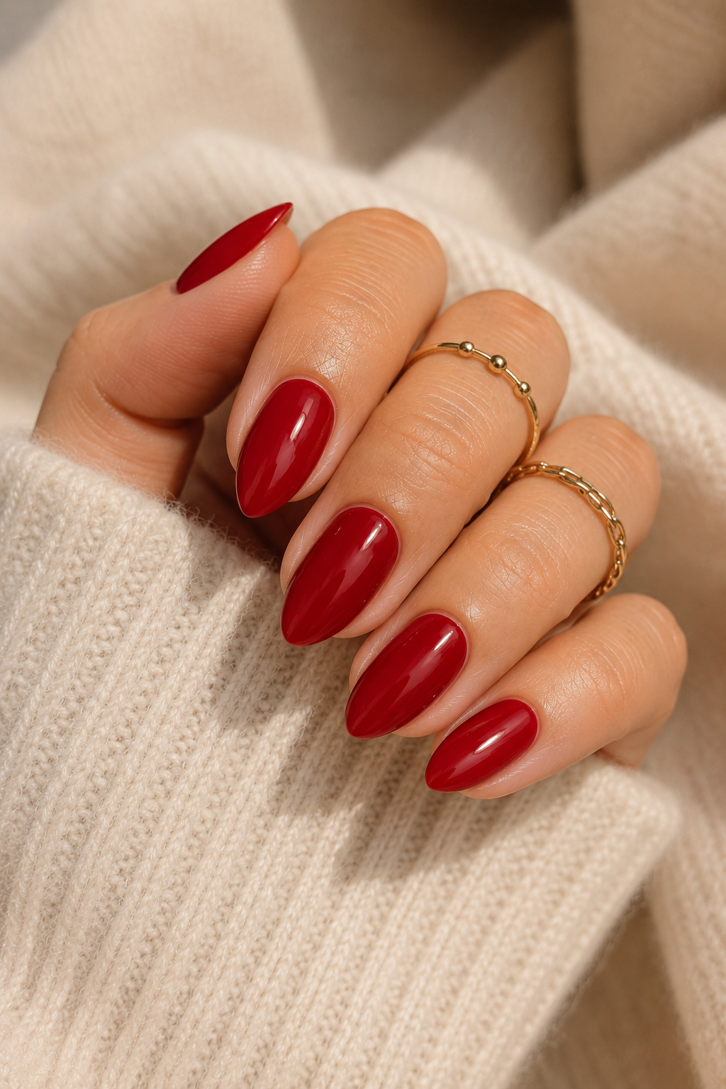 Short stiletto nails painted a true classic red with a creamy, slightly less mirror shine than a gel topcoat. The color is even and opaque.