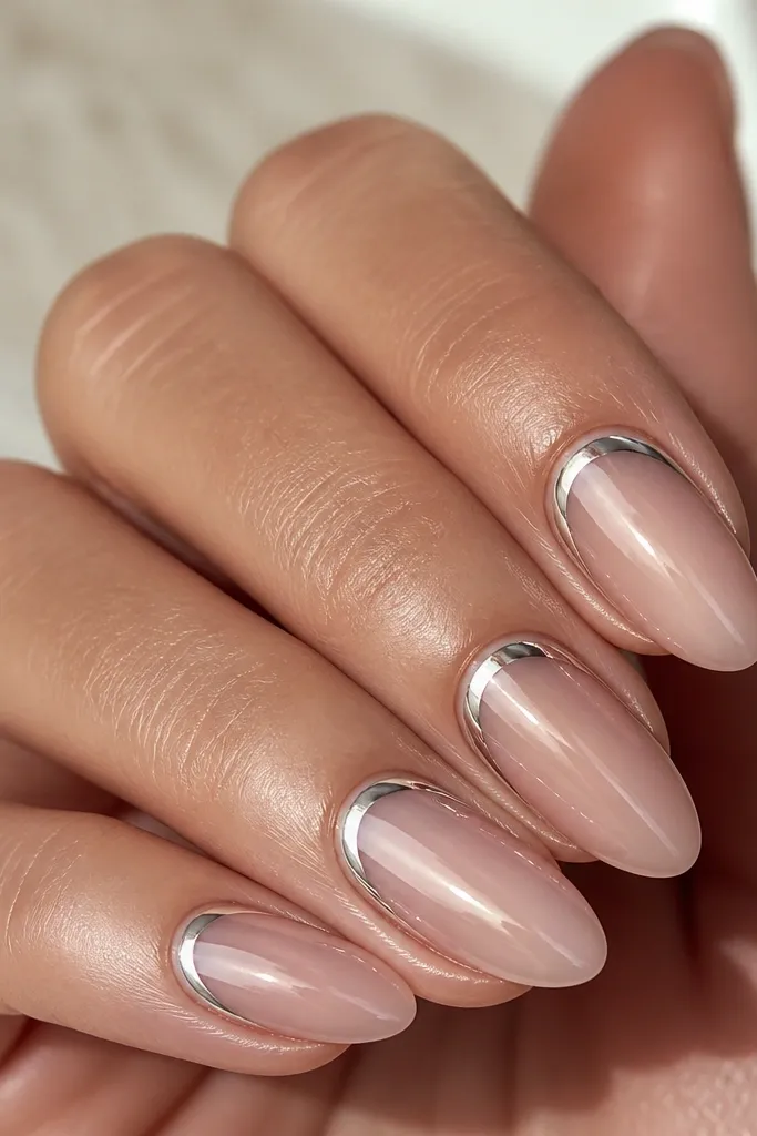Sheer pink nails with a thin chrome arc just above the cuticle line on each nail. The chrome is mirror-silver with a soft pink tint from the base. The rest of the nail is clean and glossy.