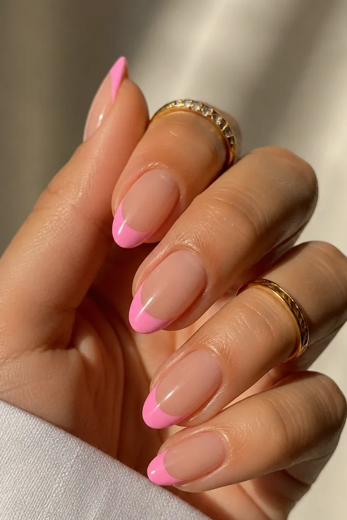 Nails have a milky pink base. The tips have a half-moon shape in candy pink near the center of each nail, leaving a clean gap at the very tip. Glossy finish, crisp edges.