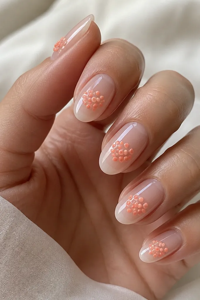 Clear jelly nails with a cluster of peachy orange dots near the center; glossy and dimensional; tiny dots look like candy sprinkles.