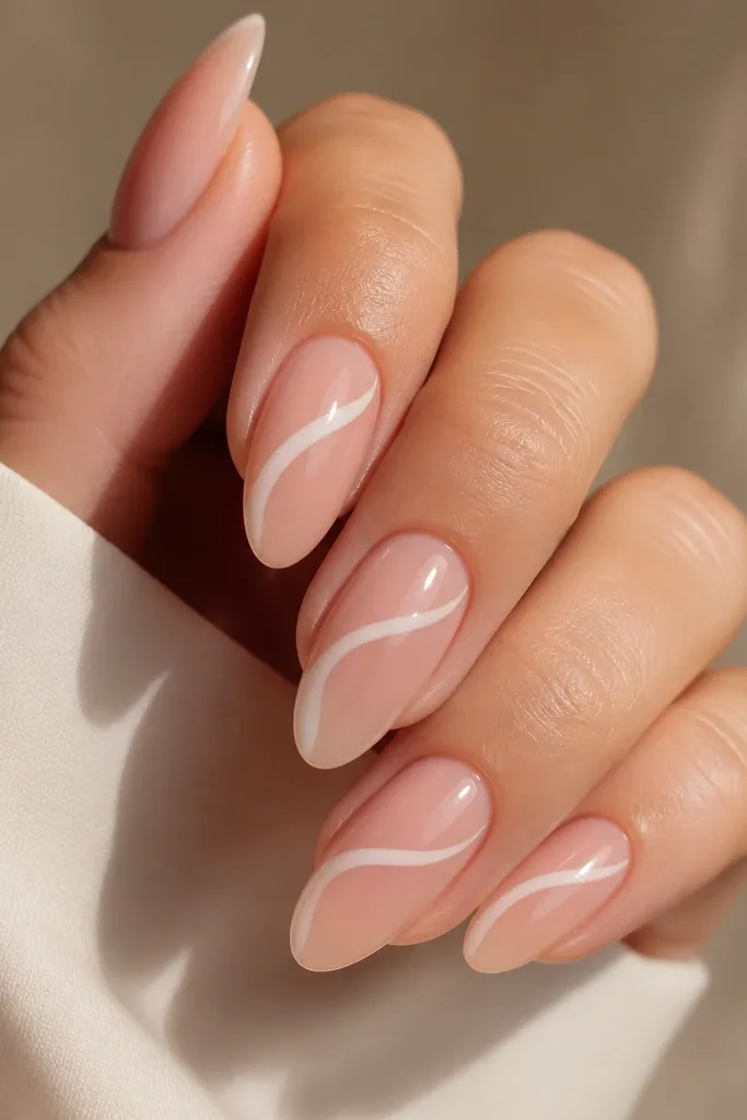 Short nails with nude base; a milky white swooping line crosses diagonally from near cuticle to near tip on each nail; glossy.