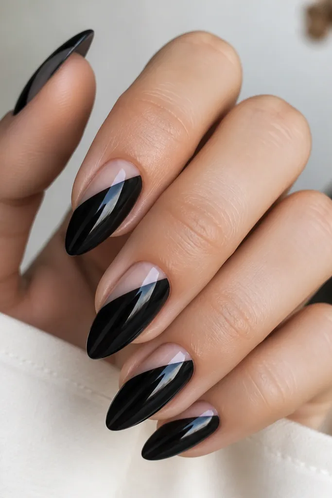Short stiletto nails painted glossy black; each nail has a clear diagonal cutout from near the cuticle down toward the side, leaving negative space; high shine and crisp edges.