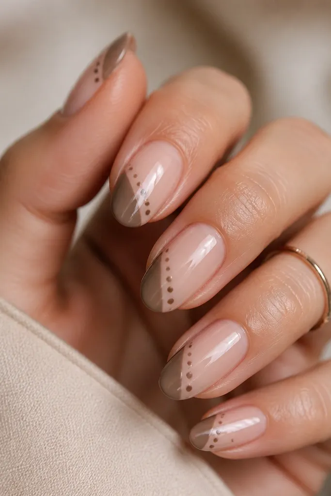 Nude nails with a taupe French tip. Two small brown dot rows run diagonally from left-lower to right-upper across the tip area.