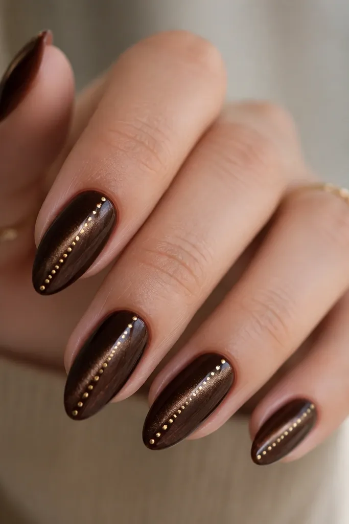 Espresso brown cat eye nails with tiny gold micro dots placed in a line that follows the magnetic streak from near cuticle to tip.
